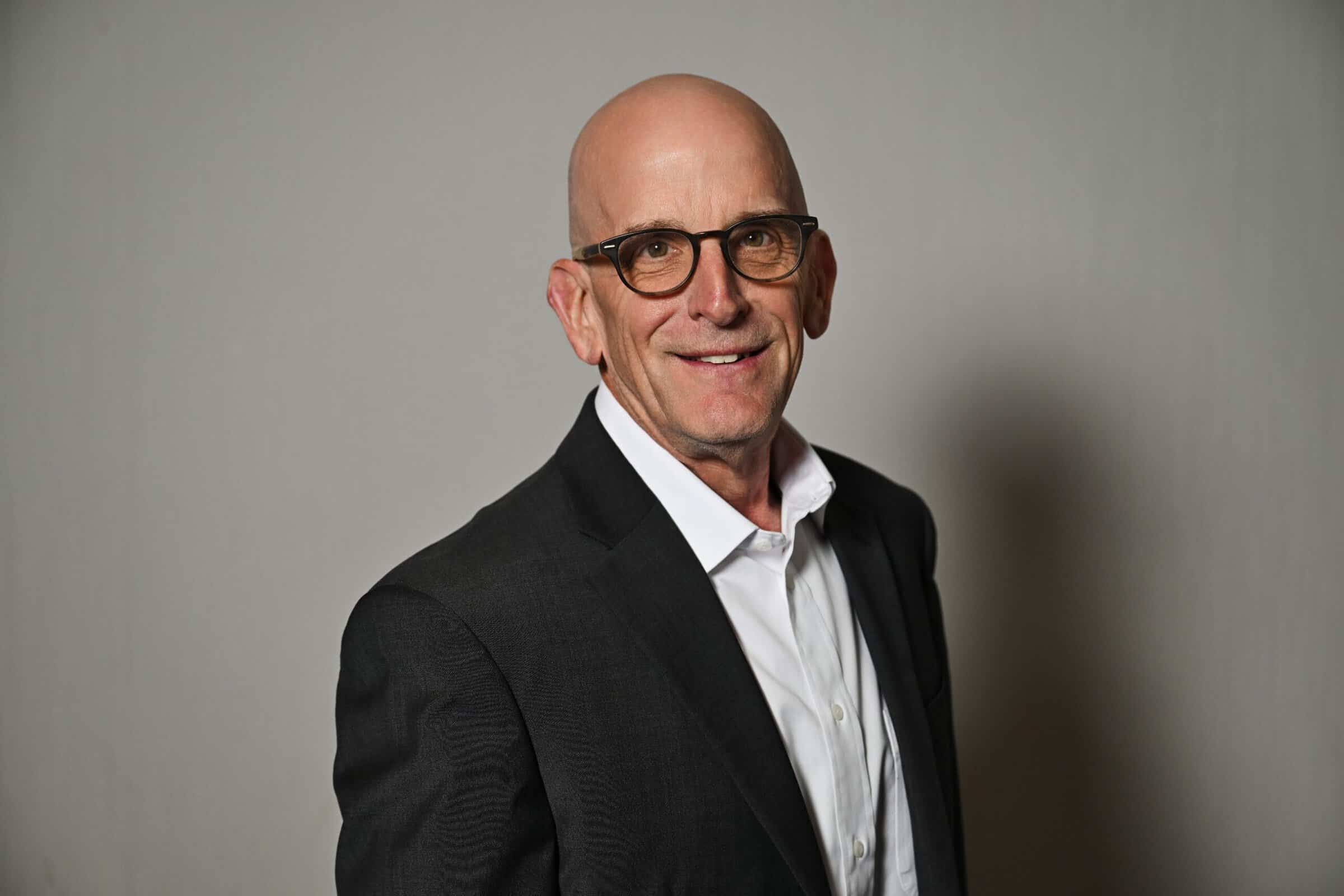 Bob Adams, Managing Director of ENSE, smiling in a professional headshot wearing a dark grey suit jacket and white shirt.