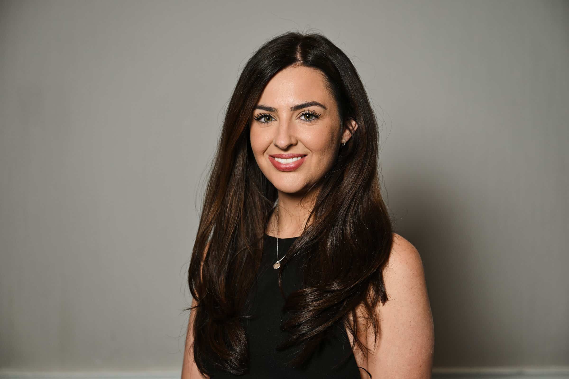 Chloe Kendall, Marketing Consultant for ENSE, smiling in a professional headshot wearing a black dress.