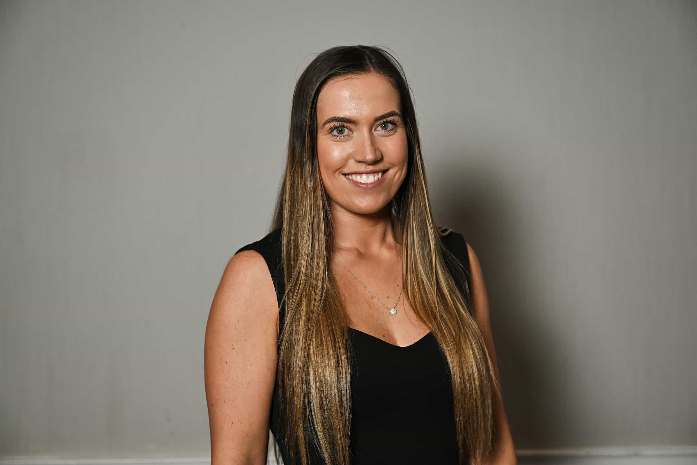 Jess Blackburn, Sales Administrator at ENSE, smiling in a professional headshot wearing a black dress.